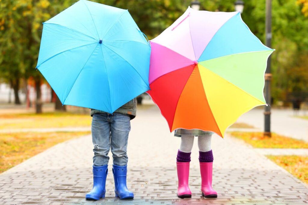bambini con la pioggia in giro a camminare
