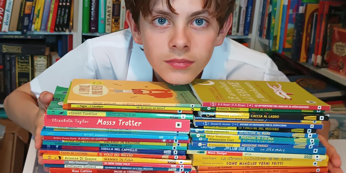 Kid con i libri. montagna di libri