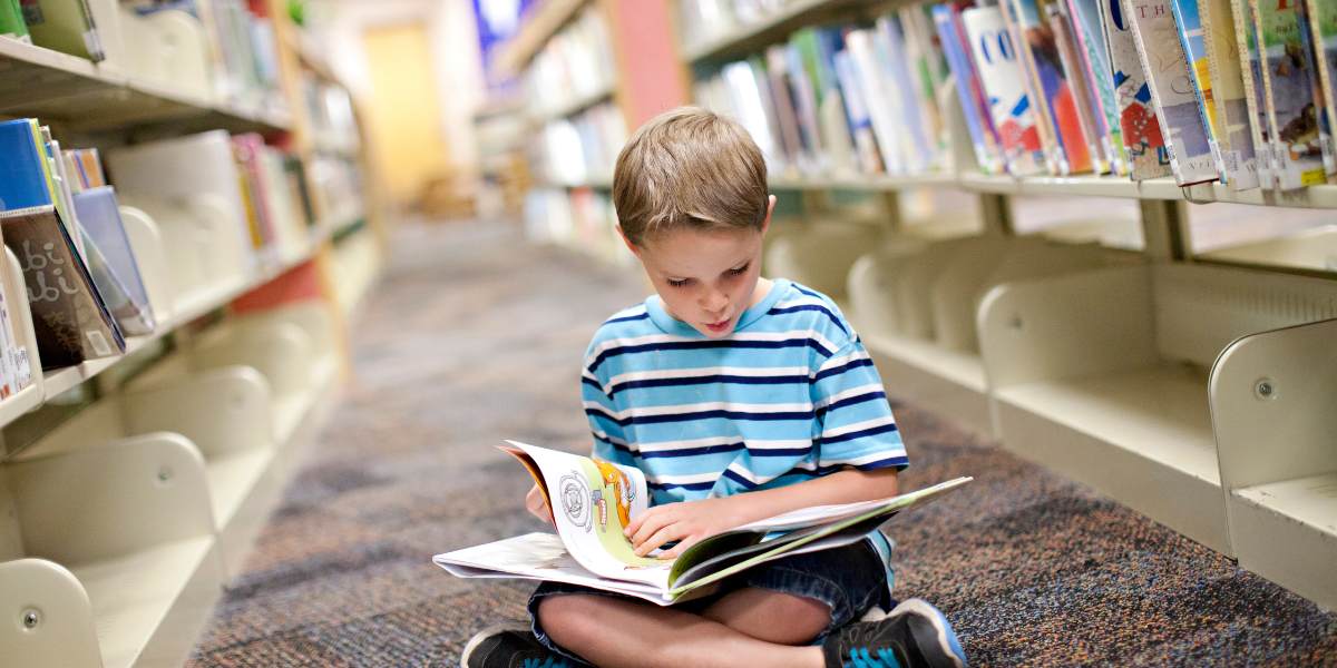 bambino legge in biblioteca